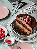 Chocolate truffle cake with raspberries and chocolate decoration on top