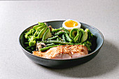 Ketogenic low carb diet dinner grilled salmon, avocado, broccoli, green bean and soft boiled egg