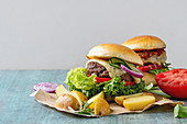 Two Homemade fast food burgers classic hamburger or cheeseburger with beef, salad, cheese and tomato
