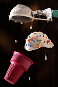 Fliegende Eiskugel mit bunten Zuckerstreuseln, Eiswaffel und Eiskugelformer
