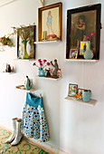 Pictures, vases and knick-knacks on small shelves on the wall