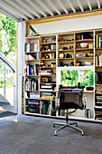 An office chair at a desk built into a bookcase