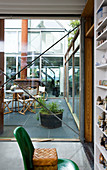 A view through the window of an atrium with garden furniture