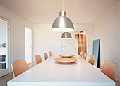 Two industrial lights above the dining table with modern chairs