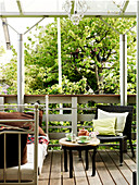 Tagesbett, Sessel und Beistelltisch auf der überdachten Terrasse