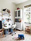 Desk in children's room with nostalgic furniture and plank floor