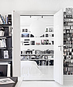 A view through an open double door into a bedroom with bookshelves