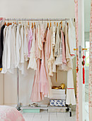 Romantic woman's dresses in pink and white on the coat rack