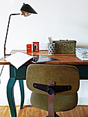 Alter Drehstuhl vor einem Holztisch als Schreibtisch
