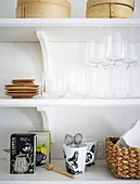 Organized shelf with glasses, tea, cups, and other kitchen accessories