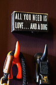 Funny wall hooks in the shape of a dog's tail with a message above