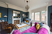 Pinkes Sofa im klassischen Wohnzimmer im Altbau mit Erker