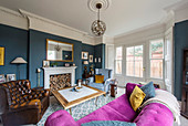 Pink sofa in classic living room with bay window in period building