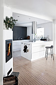 White island counter, wooden floor and wood-burning stove in open-plan kitchen