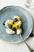 Meringue nests with lemon curd and blueberries on a plate