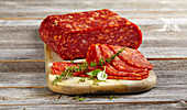 Sliced spicy Italian salami spianata calabria piccante on a wooden board