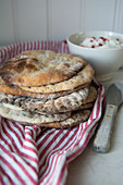 A stack of flatbreads on a tea towel