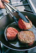 Beef medallions being fried
