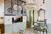 Console table, gilt-framed mirror, chandelier and partition in living room