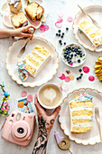 Kuchenstücke, Kaffee und Blaubeeren auf Geburtstagstisch