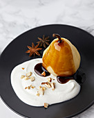 Poached pears with spices served with mascarpone and cream, topped with caramel sauce
