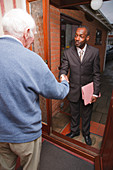 Older man welcoming visitor