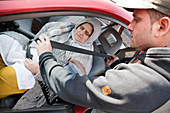 Elderly south Asian woman being helped with car seat belt