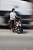 Mother trying to cross road with baby as traffic speeds by