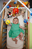 Chinese baby lying in cot