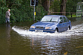 Car drives through flooded street