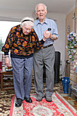 Elderly carer helping his wife with Alzheimer's disease