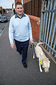 Guide Dog in harness walking with owner