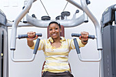 Young woman using a chest press machine