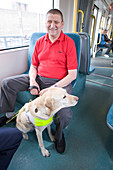 Vision impaired man with guide dog travelling on a tram
