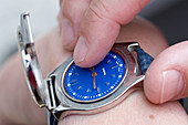 Vision impaired man using specially adapted watch