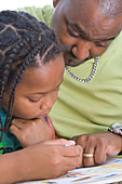 Father helping his young daughter with her homework