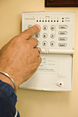 Close-up of hand of older man setting his house alarm