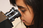 Teenager looking through microscope