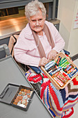 Wheelchair user selling sweets in tuck shop