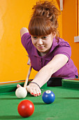 Girl playing pool in youth club