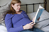 Portrait of pregnant woman reading