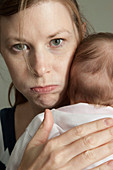 Angry mother holding young baby