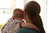 Mother and baby looking out of window