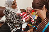 Health visitor visiting mother with baby