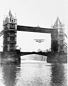 Biplane flying under Tower Bridge, Tower Hamlets, London