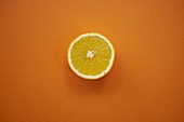 Lemon half on orange background