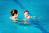 Baby boy with mother in swimming pool