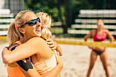 Beach volleyball players hugging
