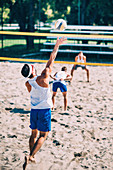 Male beach volleyball players in action