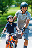 Grandfather and grandson enjoying biking and roller skating